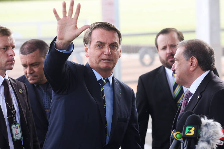 O presidente Jair Bolsonaro cumprimenta populares no Palácio da Alvorada