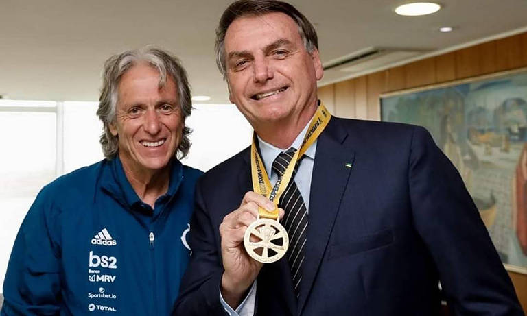 O presidente Jair Bolsonaro com a medalha da Supercopa ao lado do técnico português Jorge Jesus