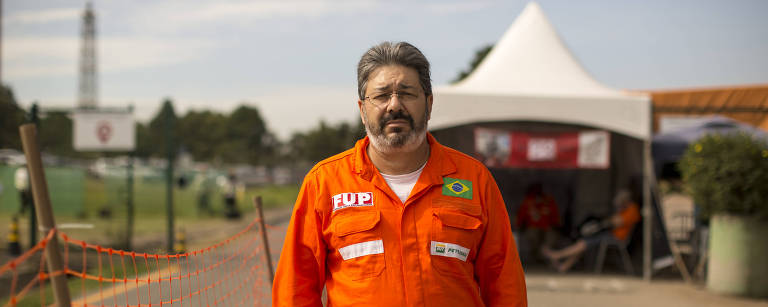 Retrato de Otêmio é pequeno, tem cabelo e barbas e grisalhos. O aposentado veste uma camisa laranja da Petrobras