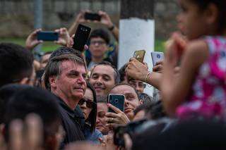 O presidente Jair Bolsonaro cumprimenta populares, em Guarujá (SP)