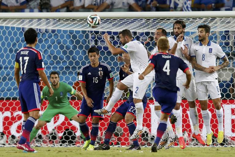 Honda (camisa 4) cobra falta durante partida da seleção do Japão contra a Grécia, na Copa do Mundo de 2014