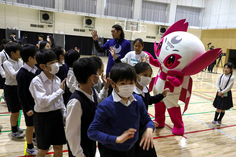 Estudantes usam máscara protetora durante evento com a mascote da Paraolimpíada de Tóquio