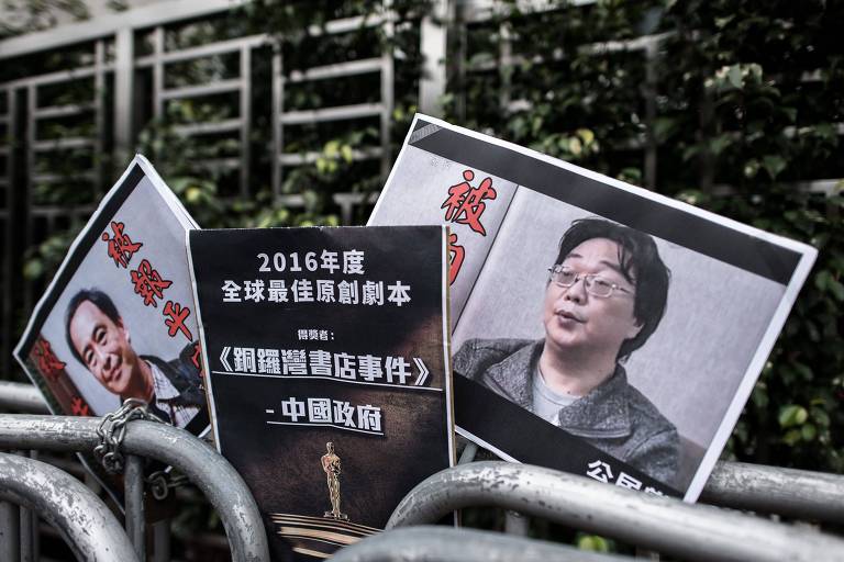 Manifestantes protestam com placas com fotos do editor de livros Gui Minhai (à direita) e seu assistente, Lee Bo 