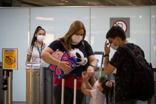 Pessoas usam máscaras no aeroporto de Guarulhos