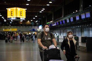 Pessoas usam máscaras no aeroporto de Guarulhos