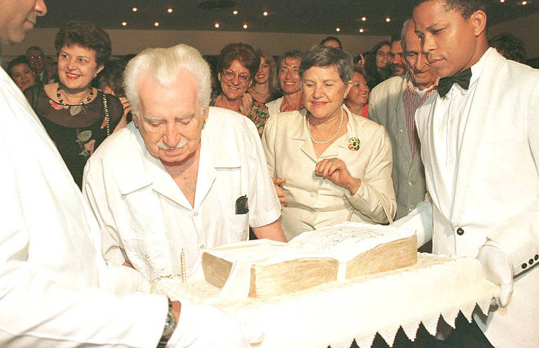 O escritor Jorge Amado corta bolo de aniversário na inauguração do teatro que leva seu nome em Salvador, ao lado da mulher, Zélia Gattai