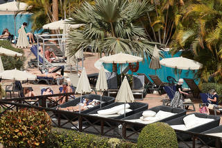 Tourists with masks in the pool of H10 Costa Adeje Palace, which is on lockdown after cases of coronavirus have been detected there in Adeje
