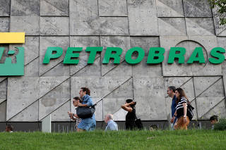 FILE PHOTO: People walk in front of the Brazil's state-run Petrobras oil company headquarters in Rio de Janeiro