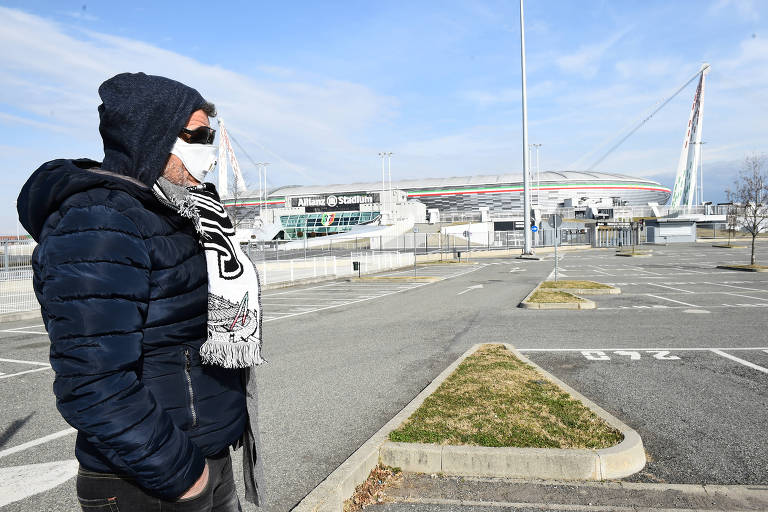 Torcedor da Juventus usa máscara de proteção em frente ao estádio do clube italiano, em Turim
