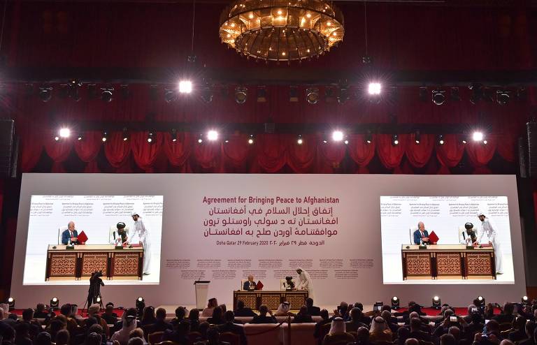 Zalmay Khalilzad, representante especial dos EUA para a reconciliação no Afeganistão, e o co-fundador do Taleban, mulá Abdul Ghani Baradar, assinam acordo de paz em Doha, no Qatar