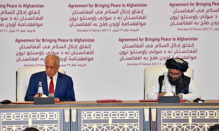 Zalmay Khalilzad, representante especial dos EUA para a reconciliação no Afeganistão, e o co-fundador do Taleban, mulá Abdul Ghani Baradar, assinam acordo de paz em Doha, no Qatar