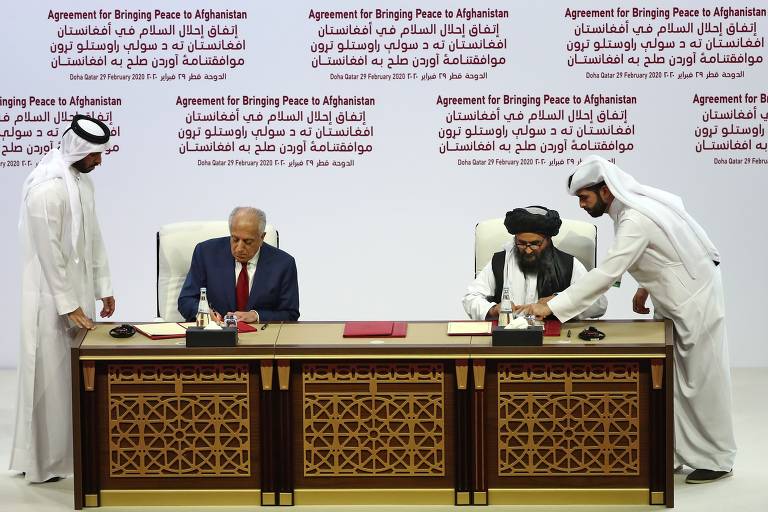 Zalmay Khalilzad, representante especial dos EUA para a reconciliação no Afeganistão, e o co-fundador do Taleban, mulá Abdul Ghani Baradar, assinam acordo de paz em Doha, no Qatar