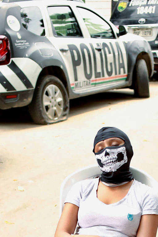 Mulher mascarada em frente a batalhão durante a mobilização de PMs em Fortaleza