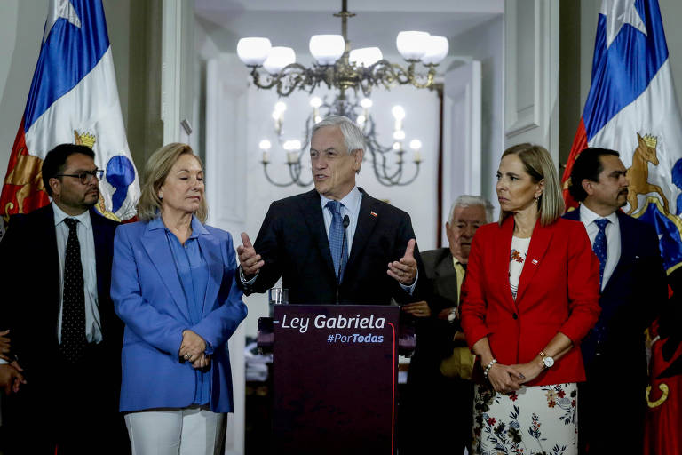 Acompanhado da primeira-dama, Cecilia Morel (de azul), e da ministra da Mulher, Isabel Plá (de vermelho), Sebastián Piñera anuncia a criação de nova lei contra feminicídio