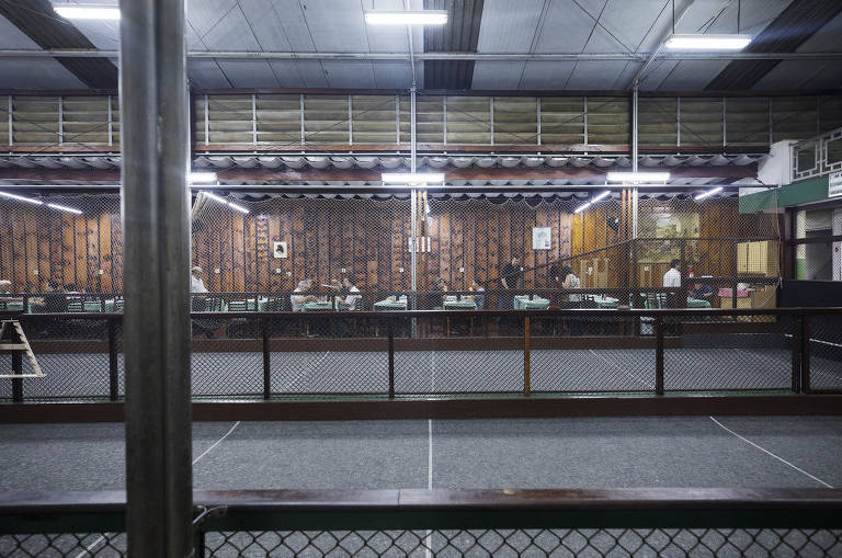 Ao lado de quadras de bocha, clientes consomem pizzas fritas no Grêmio Dramático Recreativo