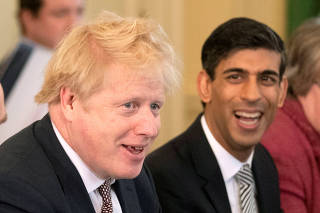 FILE PHOTO: Britain's Prime Minister Boris Johnson speaks during his first Cabinet meeting next to a new appointed Chancellor of the Exchequer, Rishi Sunak, following a reshuffle the day before, at Downing Street in London