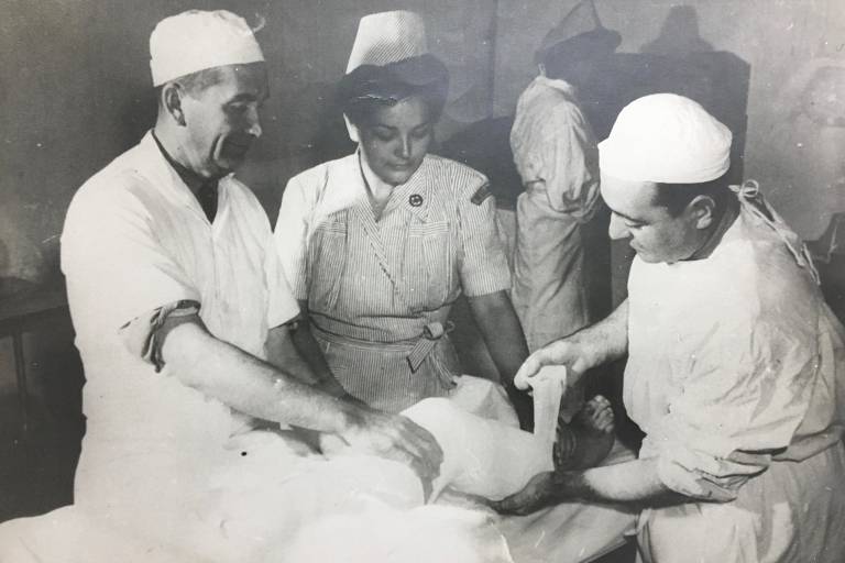 O ortopedista Lutero Vargas, filho do então Presidente do Brasil Getúlio Vargas, serviu como médico voluntário da Força Aérea. Na foto, à direita, enfaixa a perna do Sargento Fernando, ferido em combate, auxiliado pela enfermeira brasileira Regina Cerdeira Bordalo, no 12º General Hospital, em Livorno. Ao fundo, a enfermeira Ocimara Moura Ribeiro