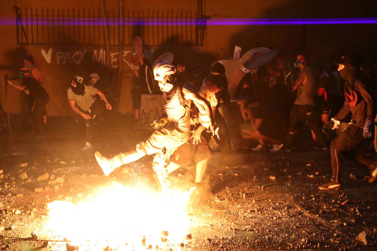 Manifestantes em meio a incêndio durante manifestação em Santiago