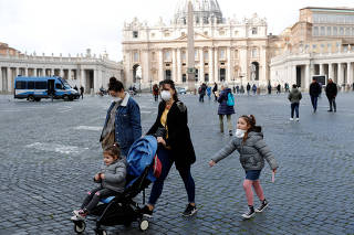 People wear protective face masks on St. Peter's Square after the Vatican reports its first case of coronavirus