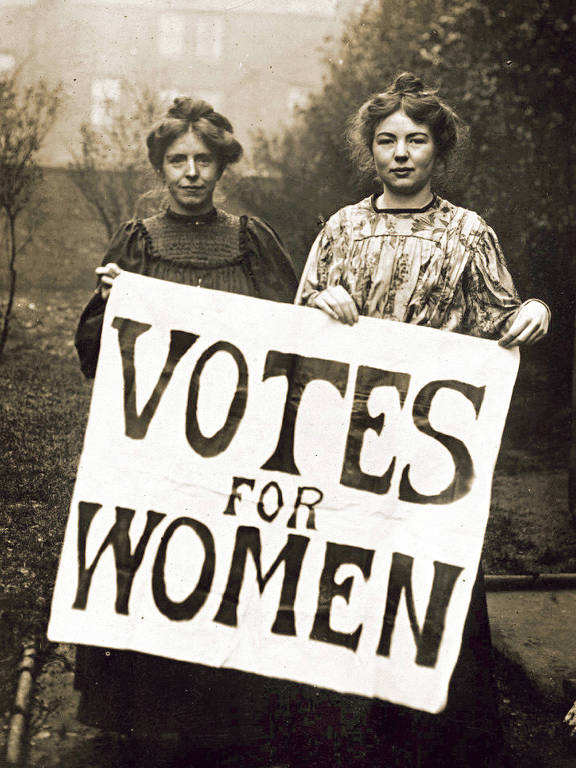 Sufragistas fazem campanha no Reino Unido 
As sufragistas inglesas Annie Kenney e Christabel Pankhurst seguram cartaz com o slogan 'Vote for Women', criado por elas e adotado pelo movimento em favor do voto feminino; elas faziam parte da WSPU, organização militante que lutou pelo sufrágio feminino no Reino Unido entre 1903 e 1917 