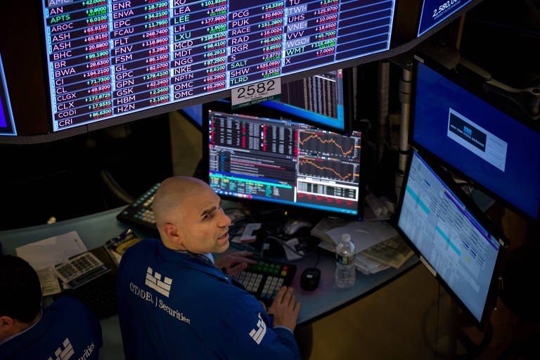 Operador da Bolsa de Nova York observa painéis com oscilações do mercado