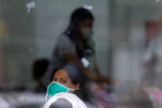A woman wears a protective face mask at the North Wing Regional Hospital after reports of the coronavirus in Brasilia