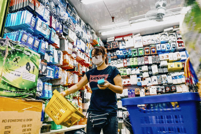 Funcionária no centro de São Paulo; lojistas usam máscara para conter risco de disseminação