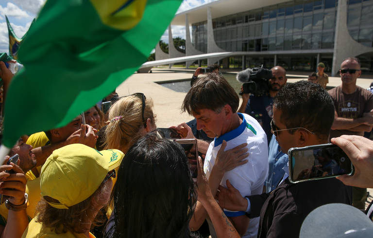 O presidente Jair Bolsonaro com apoiadores na frente do Palácio do Planalto, ao final da manifestação neste domingo (15) 
