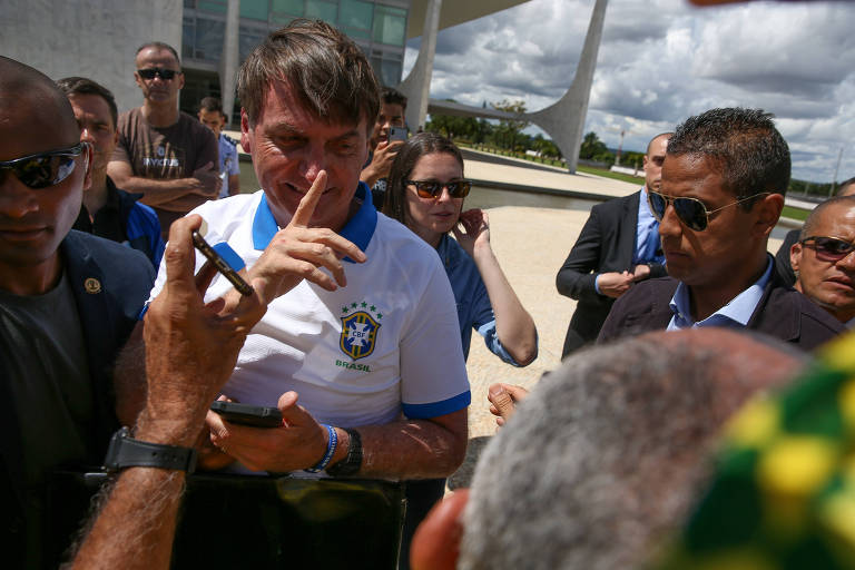 O presidente Jair Bolsonaro com apoiadores na frente do Palácio do Planalto, ao final da manifestação neste domingo (15)