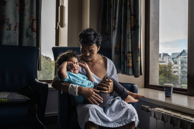 Zulfirman Syah com o filho, Roes, no hospital após ser baleado no massacre na mesquita Linwood, em Christchurch