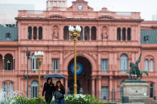 Pedestrians walk in front of the Casa Rosada Presidential Palace during the outbreak of the coronavirus disease (COVID-19), in Buenos Aires