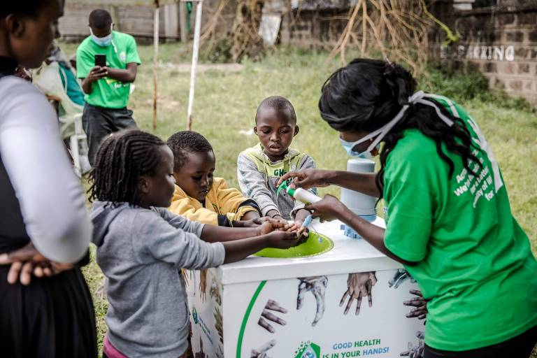 Crianças recebem instruções de como lavar as mãos em frente ao hospital Mbagathi, em Nairóbi, no Quênia
