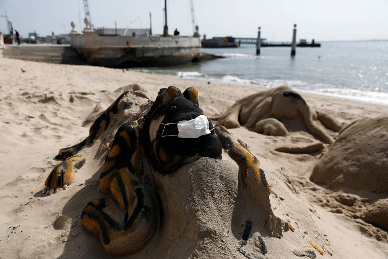 No Cais das Colunas, em Lisboa, até as esculturas de areia usam máscaras de proteção contra o coronavírus