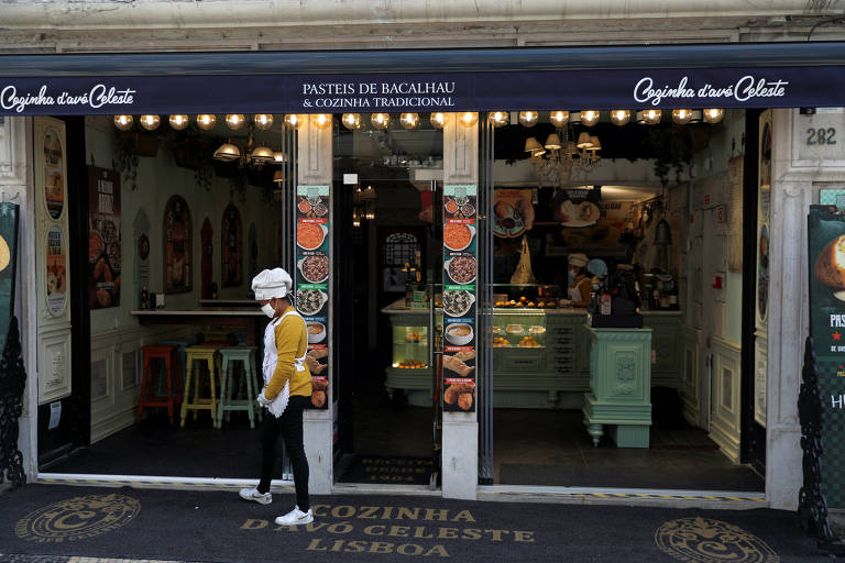Garçonete usa máscara de proteção em um restaurante da rua Augusta, em Lisboa