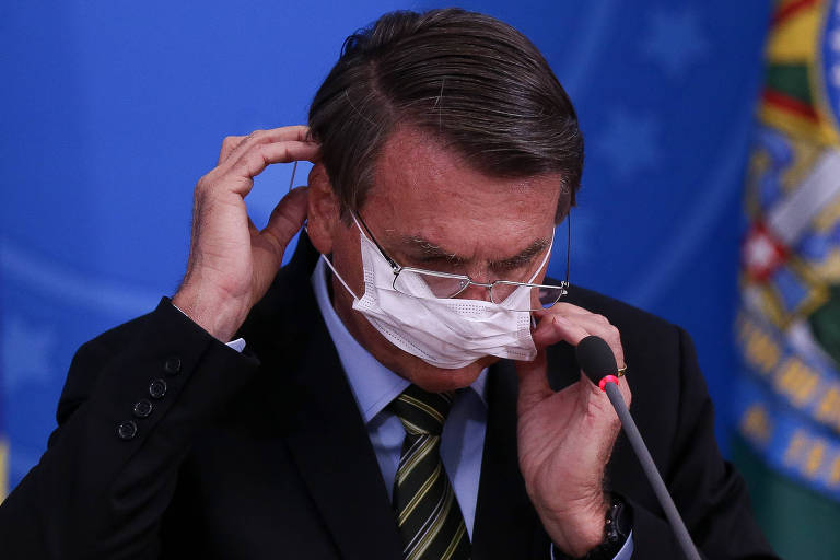 O presidente Jair Bolsonaro, de máscara, durante pronunciamento 