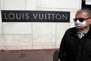 A man wearing a protective face mask walks past a Louis Vuitton shop on the Croisette in Cannes where the Cannes Film Festival and the Cannes Lions take place, as a lockdown is imposed to slow the rate of the coronavirus disease (COVID-19), in France