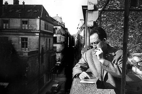 1955 Literatura: o escritor francês Albert Camus fuma na sacada da editora pela qual publicou 