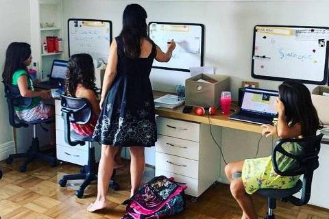 Mãe ajuda filhas trigêmeas a estudarem em casa durante suspensão das aulas em razão da pandemia de coronavírus