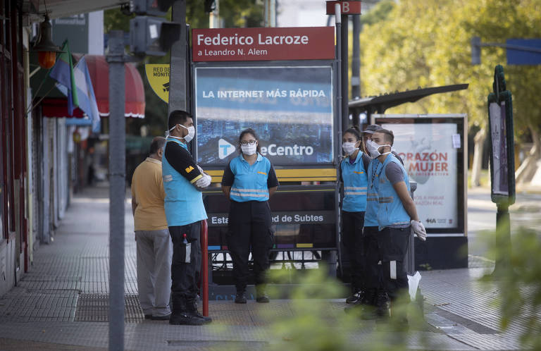 Agentes da Diretoria de Trânsito de Buenos Aires controlam a entrada de uma estação de metrô durante o terceiro dia da quarentena obrigatória decretada pelo governo argentino