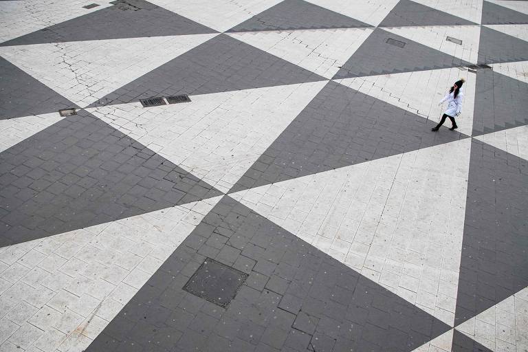 Mulher atravessa a quase deserta praça Sergel, em Estocolmo