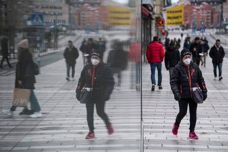 Mulher usando máscara de proteção em Estocolmo, Suécia. País contraria tendência global de isolamento