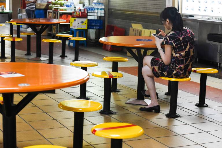 Em Singapura, cadeiras são marcadas com fitas vermelhas pelas autoridades, que determinaram o distanciamento social; o país, que teve os seus primeiros casos em janeiro, mantêm a epidemia controlada com 345 casos do novo coronavírus 
