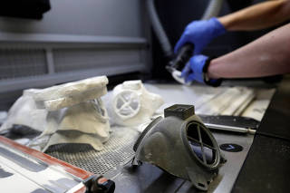 A researcher works on a prototype of a respirator using 3D-printing technology in Prague