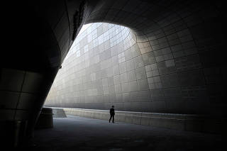 A person wearing a mask to prevent contracting the coronavirus disease (COVID-19) walks along an empty street in Seoul,