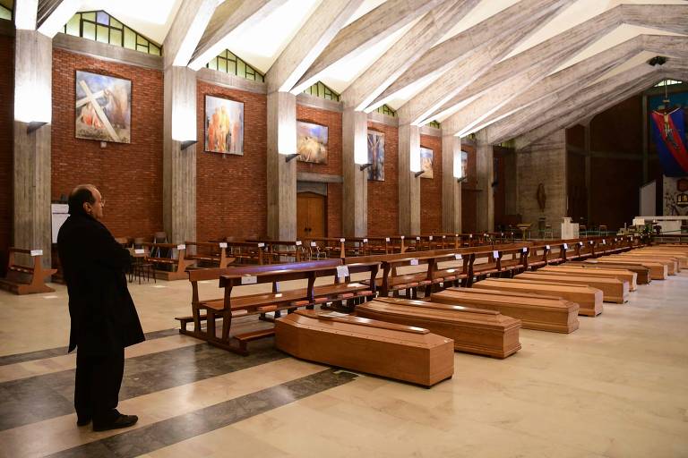Pároco dom Mario, diante de caixões na igreja de são José, em Seriate, perto de Bergamo, na Lombardia, Itália