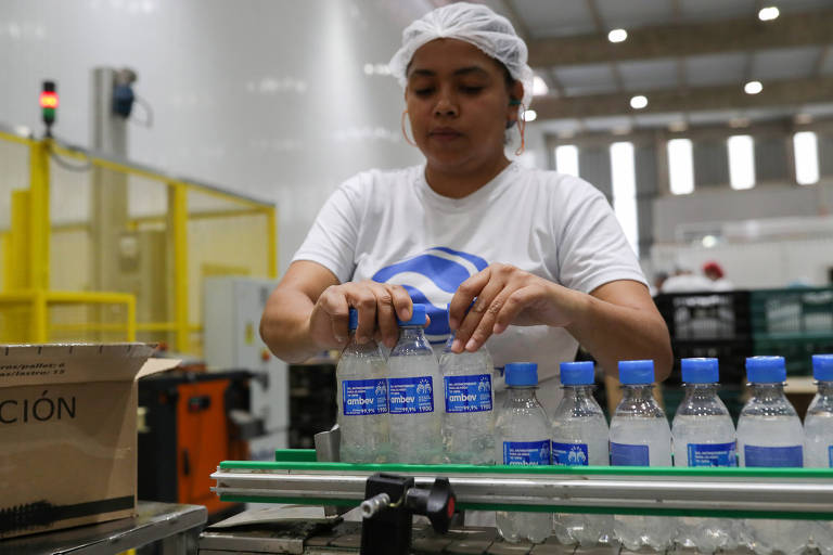 Empregada da Ambev na linha de produção de álcool gel fabricado para o combate ao coronavírus