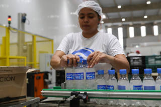 A employee carries ethanol-based hand sanitizers in AGE do Brasil factory, hired by brewing Ambev to produce hand sanitizers to public hospitals during the coronavirus disease (COVID-19) outbreak in Vinhedo