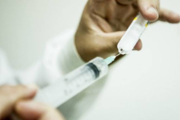 Médico manipula seringa com vacina 