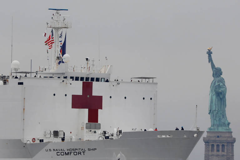 Navio-hospital da Marinha americana passa pela Estátua da Liberdade, em Nova York