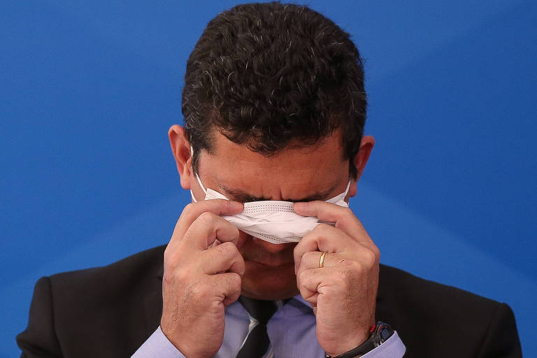 O ministro da Justiça, Sergio Moro, coloca máscara durante entrevista sobre medidas do governo contra a epidemia de coronavírus